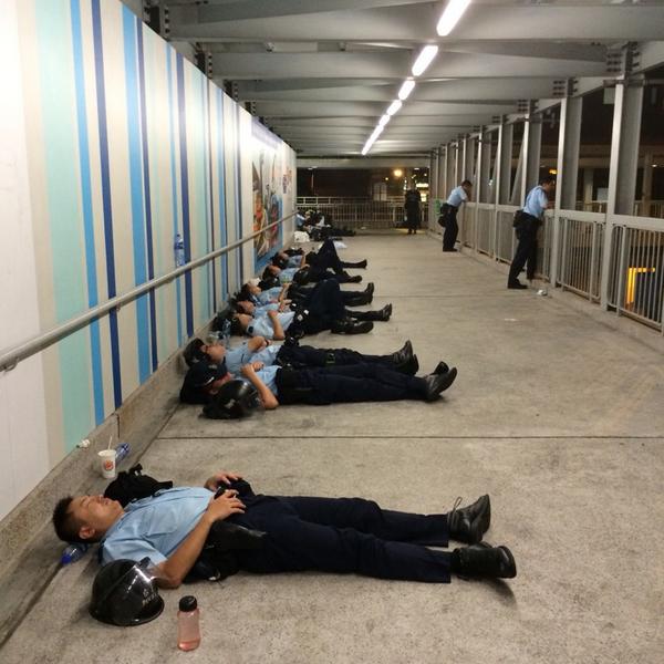 Tired police officers take a break during what has been a long night of protests in Hong Kong 