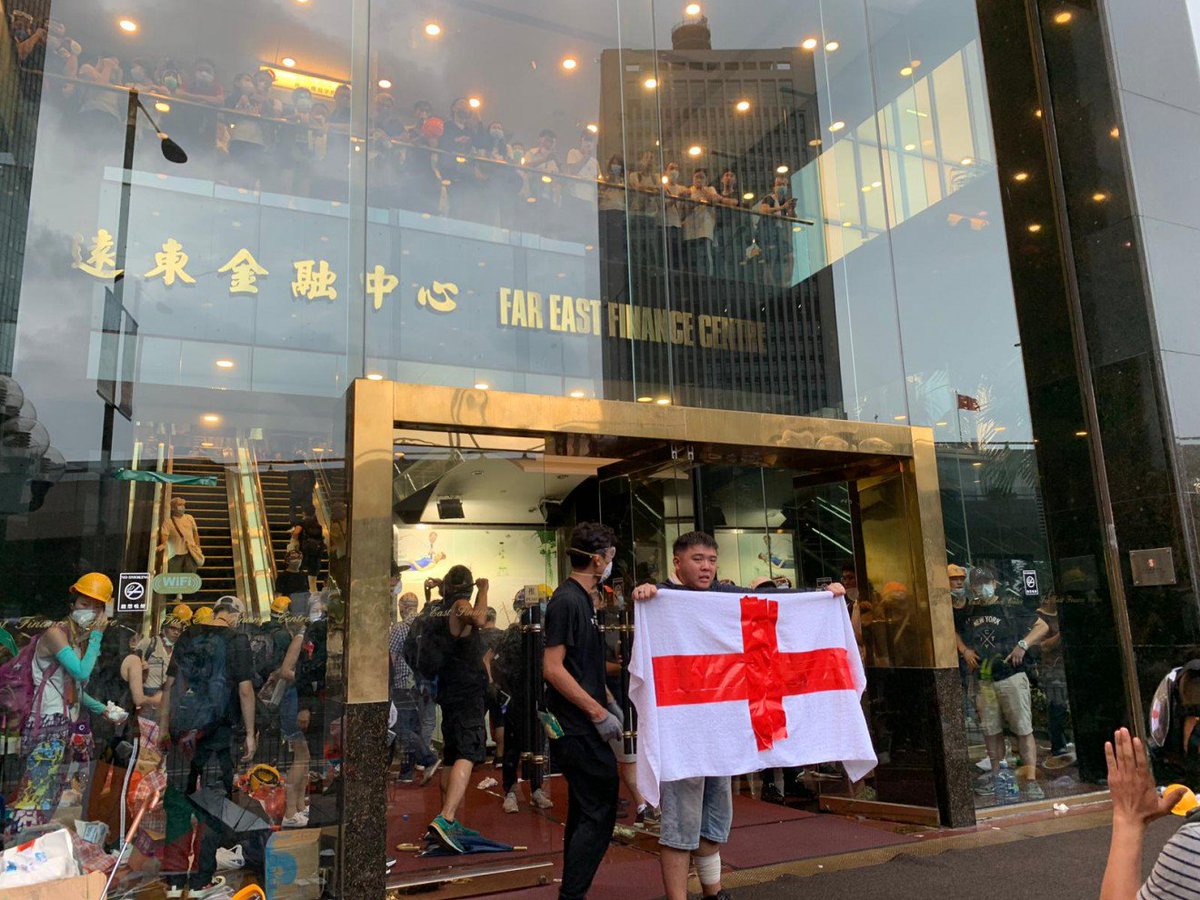 Police are trying to seal shut the doors of the Far East Finance Centre on Harcourt Road, where a group of protesters have barricaded themselves inside. Among the group are first aiders.    