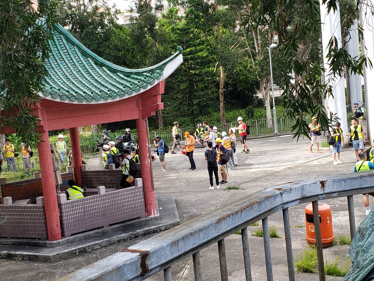 Not the best view but currently large number of 727march goers are besieging Nam Bin Wai, a walled village where many white-clad assailants were seen on 7.21. Riot police are stationing in a carpark in front of the village entrance, trying to keep two parties apart. #YuenLong