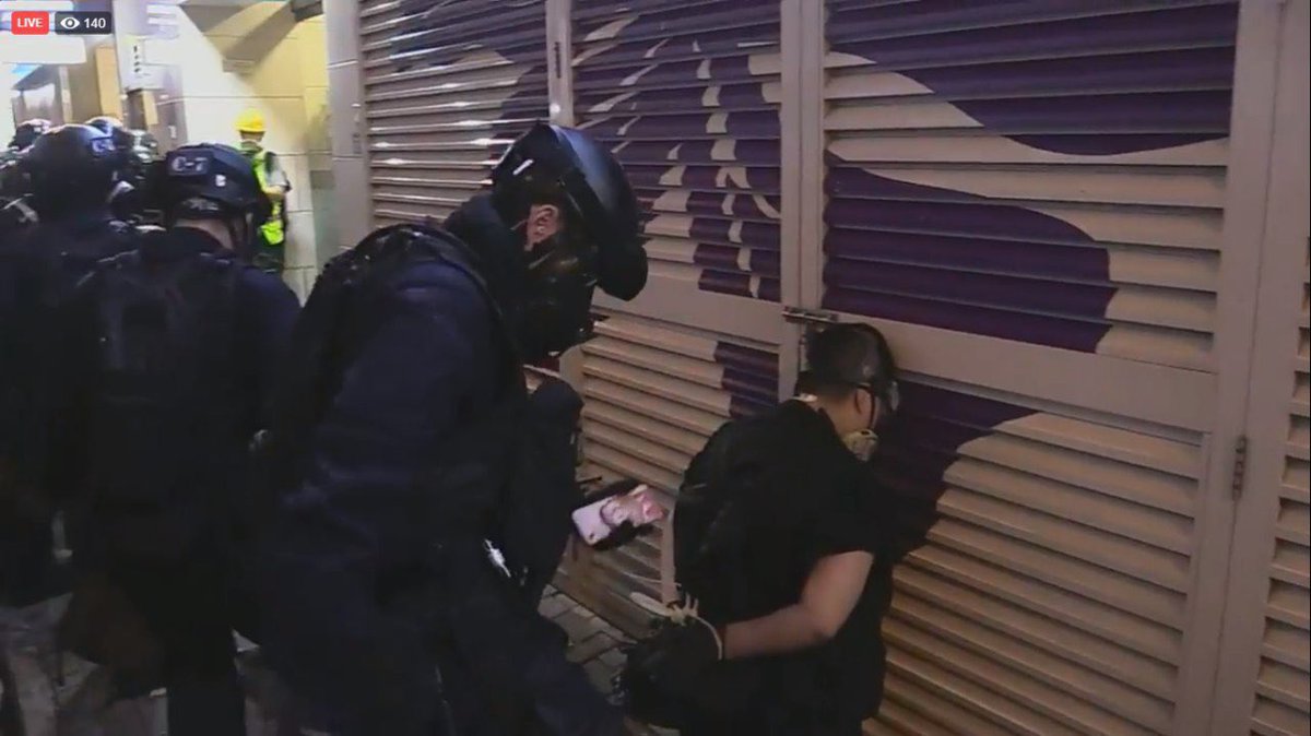 21:55 Arrested protestors made to face the wall, with hands tied to their backs