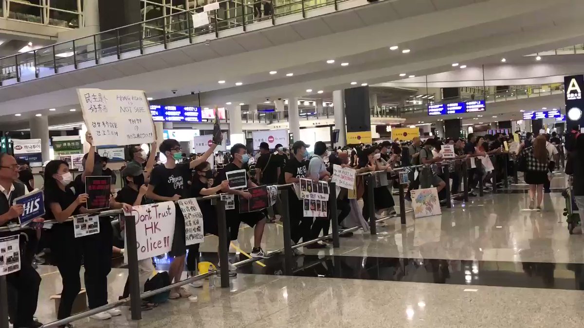 Chants of Don't trust Hong Kong police as flights are still landing. Still a steady group of protesters at Hong Kong airport