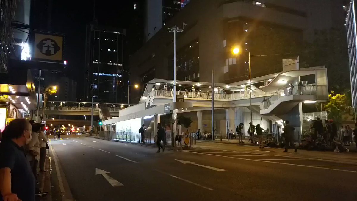 Hennessy Rd is calm. Riot police on guard on the footbridge outside their headquarters. Exhausted reporters sitting on pedestrian sidewalks and road dividers. Small number of onlookers and passengers linger around. No protester in general