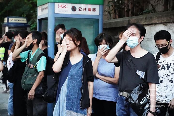 On Thursday evening, dozens of Hongkongers gathered outside Tsim Sha Tsui Police Station on the occasion of World Vision Day, in support of a woman who was shot by a police projectile in the right eye in August.  Photo: Stand News. 