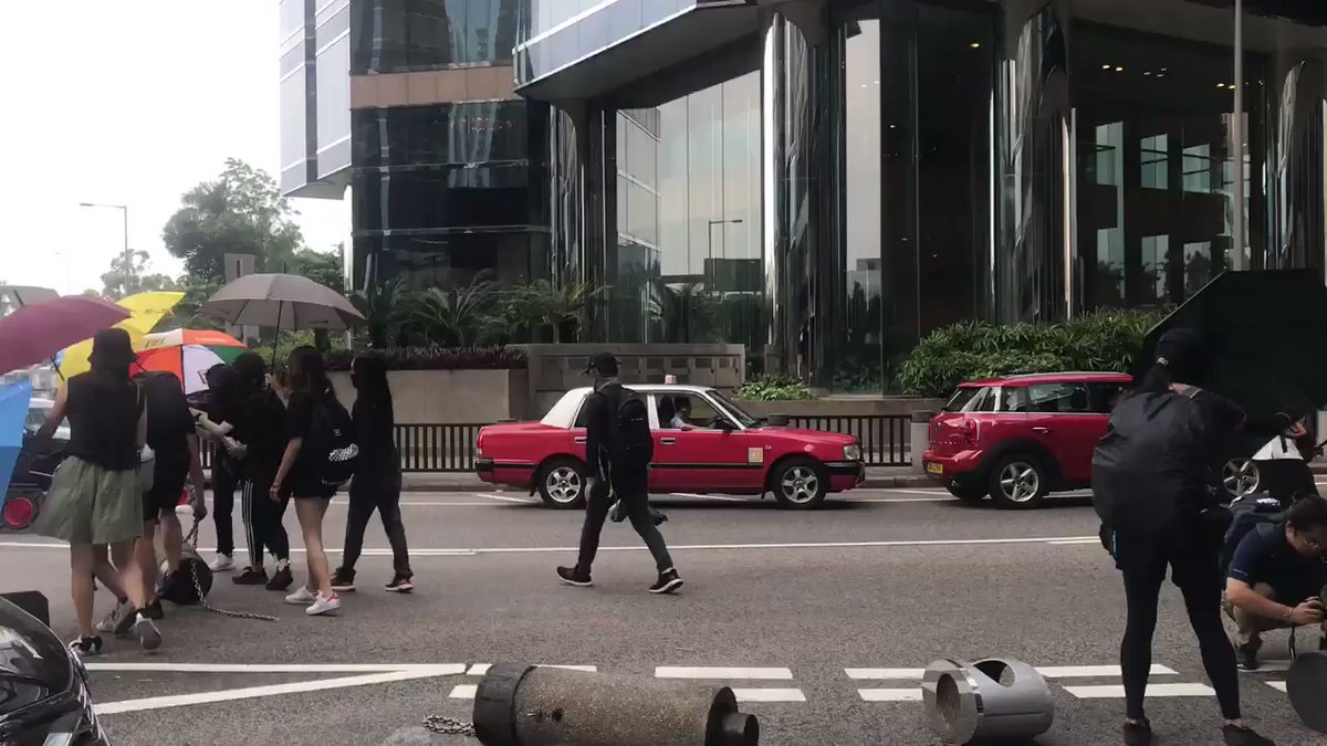Outside the mall on Tai Koo Wan Road, bollards are being rolled onto road to stop traffic