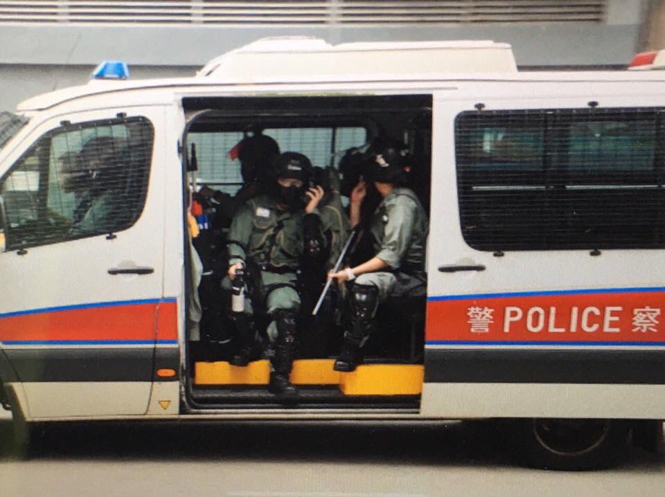 Protesters set up makeshift roadblocks and graffitied a Maxim's restaurant in Tsuen Wan on Sunday. Police vehicles drove with their doors open to facilitate quick arrests. Photo: United Social Press.