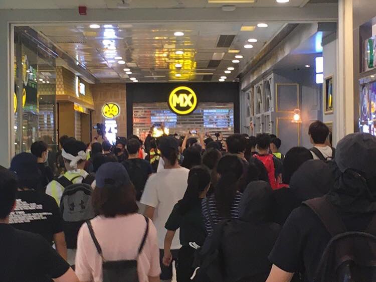 Protesters set up makeshift roadblocks and graffitied a Maxim's restaurant in Tsuen Wan on Sunday. Police vehicles drove with their doors open to facilitate quick arrests. Photo: United Social Press.