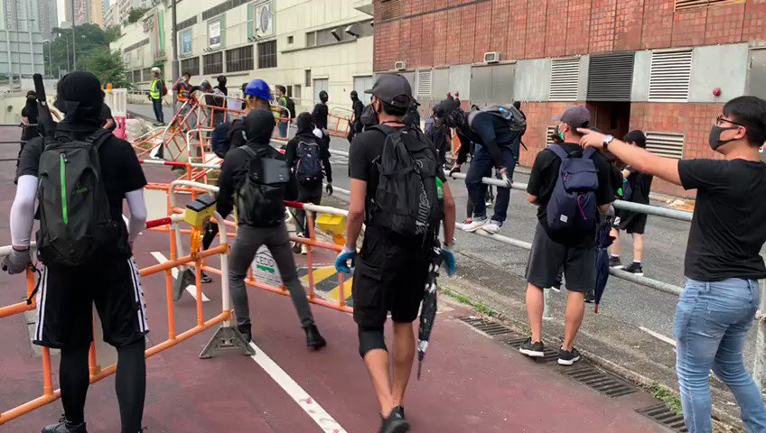 A police officer pulls out his pistol outside New Town Plaza in Sha Tin.  Video: SCMP/Mantai Chow