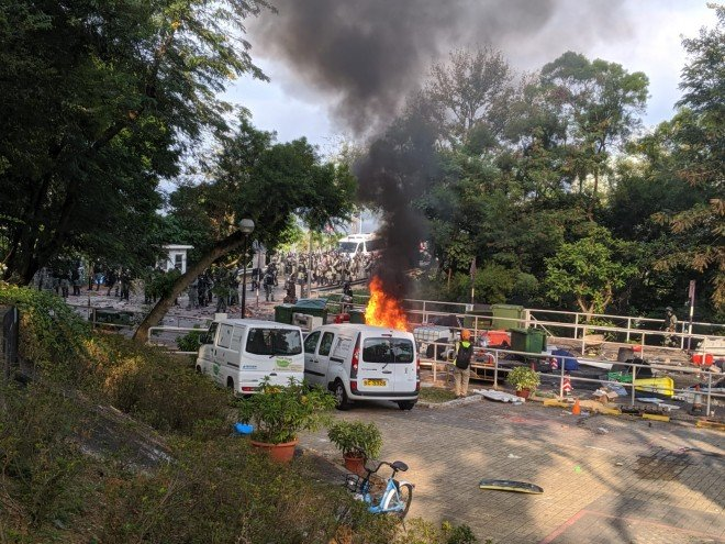 At Chinese University, protesters retreat after about 15 minutes of repeated volleys of tear gas from police. Some objects are set on fire. At least one protester was subdued by officers on the ground.   