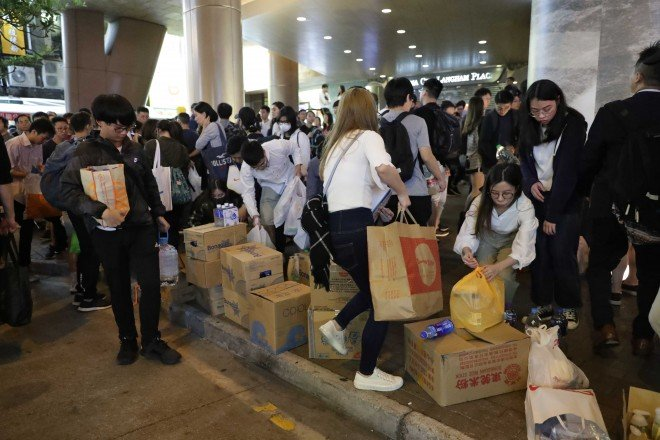 At Langham Place in Mong Kok, volunteers are dropping supplies donated to protesters at Chinese University. This action is in response to calls on internet platforms 