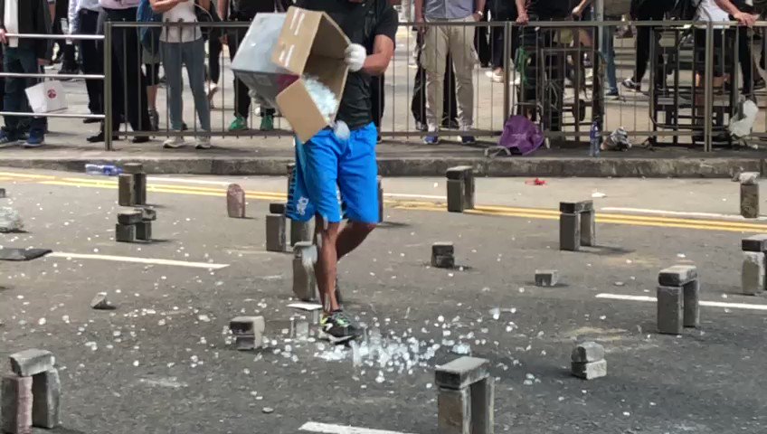 A protester has scattered shattered glass on Pedder Street where they earlier built a sophisticated barricade with bamboo sticks and bricks.  Video: SCMP/Stanley Shin